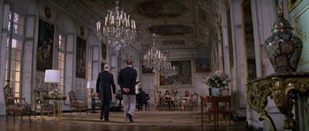 Movie still from “Moonraker” (1979), directed by Lewis Gilbert – Two men are walking through a room with chandeliers; Wide shot, Low angle