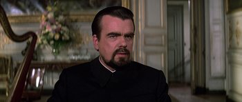 Movie still from “Moonraker” (1979), directed by Lewis Gilbert – A person with a beard wearing a suit; Close Up shot, Low angle