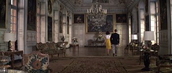 Movie still from “Moonraker” (1979), directed by Lewis Gilbert – A man and a woman are walking in a room; Wide shot, Low angle