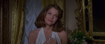Movie still from “Moonraker” (1979), directed by Lewis Gilbert – A beautiful woman in a white dress holding a cell phone; Close Up shot, Over the shoulder angle