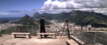 Movie still from “Moonraker” (1979), directed by Lewis Gilbert – A man standing on a bench looking over a city; Extreme Wide shot, High angle