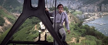 Movie still from “Moonraker” (1979), directed by Lewis Gilbert – A man standing on the side of a metal structure; Wide shot, Low angle