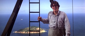 Movie still from “Moonraker” (1979), directed by Lewis Gilbert – A man standing next to a ladder on top of a hill; Medium shot, Low angle
