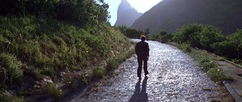Movie still from “Moonraker” (1979), directed by Lewis Gilbert – A person is walking down a path near a mountain; Extreme Wide shot, High angle