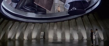 Movie still from “Moonraker” (1979), directed by Lewis Gilbert – A man standing on a platform in front of a building; Extreme Wide shot, Low angle