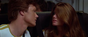 Movie still from “Moonraker” (1979), directed by Lewis Gilbert – A man and a woman sitting next to each other on a bus; Close Up shot, Low angle
