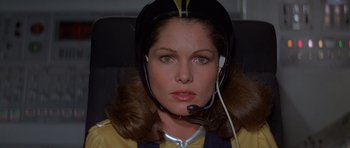 Movie still from “Moonraker” (1979), directed by Lewis Gilbert – A woman wearing a helmet with a headset on her head; Close Up shot, Low angle