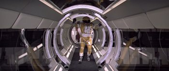Movie still from “Moonraker” (1979), directed by Lewis Gilbert – A man in a space suit walking through a tunnel; Wide shot, Overhead angle