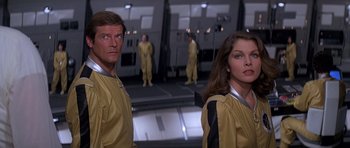 Movie still from “Moonraker” (1979), directed by Lewis Gilbert – A man and a woman standing next to each other; Medium shot, Low angle