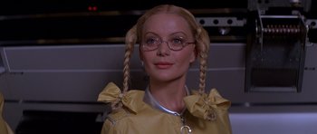 Movie still from “Moonraker” (1979), directed by Lewis Gilbert – A woman with pigtails wearing glasses and a yellow jacket; Close Up shot, Low angle