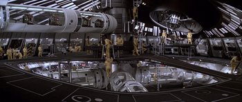 Movie still from “Moonraker” (1979), directed by Lewis Gilbert – Some people are working in an industrial setting; Extreme Wide shot, High angle