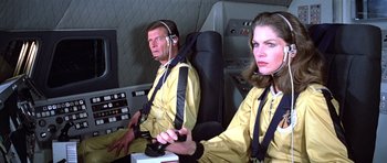 Movie still from “Moonraker” (1979), directed by Lewis Gilbert – A man and a woman are sitting in a plane; Medium shot, High angle