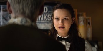 Movie still from “13 Reasons Why” (2017), created by Brian Yorkey – A young woman wearing a black bow tie; Close Up shot, Over the shoulder angle