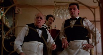 Movie still from “Moonstruck” (1987), directed by Norman Jewison – A group of waiters standing next to each other in a restaurant; Medium shot, Low angle
