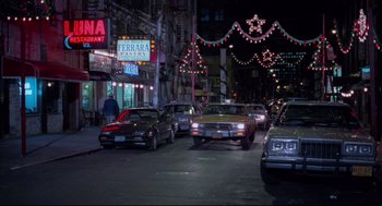 Movie still from “Moonstruck” (1987), directed by Norman Jewison – A bunch of cars parked on the side of the street; Extreme Wide shot, Low angle