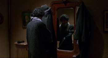 Movie still from “Moonstruck” (1987), directed by Norman Jewison – A man is looking in the mirror in front of a mirror; Medium shot, Over the shoulder angle
