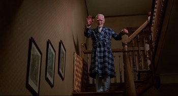 Movie still from “Moonstruck” (1987), directed by Norman Jewison – An older man in a robe waving down a flight of stairs; Wide shot, Low angle