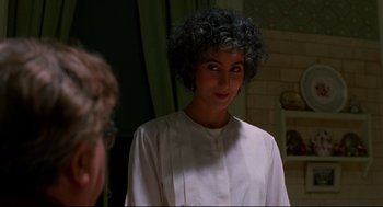 Movie still from “Moonstruck” (1987), directed by Norman Jewison – A woman in a white shirt is standing in front of a mirror; Close Up shot, Over the shoulder angle