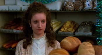 Movie still from “Moonstruck” (1987), directed by Norman Jewison – A woman standing in front of a display of food; Close Up shot, Over the shoulder angle