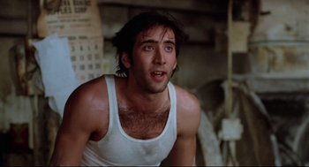 Movie still from “Moonstruck” (1987), directed by Norman Jewison – A man in a tank top is looking at the camera; Close Up shot, Low angle