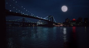 Movie still from “Moonstruck” (1987), directed by Norman Jewison – A large body of water near a city at night time; Extreme Wide shot, Low angle