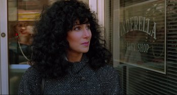 Movie still from “Moonstruck” (1987), directed by Norman Jewison – A person wearing a jacket with long curly hair; Close Up shot, Over the shoulder angle