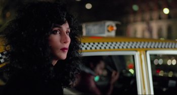 Movie still from “Moonstruck” (1987), directed by Norman Jewison – A woman with curly black hair sitting in a taxi cab; Close Up shot, Over the shoulder angle