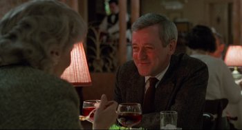 Movie still from “Moonstruck” (1987), directed by Norman Jewison – An older man sitting at a table with a woman; Close Up shot, Over the shoulder angle
