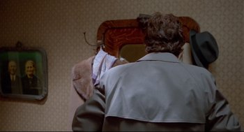 Movie still from “Moonstruck” (1987), directed by Norman Jewison – A man standing in front of a mirror in a room; Close Up shot, Over the shoulder angle