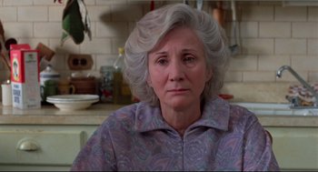 Movie still from “Moonstruck” (1987), directed by Norman Jewison – An older woman sitting at a table in a kitchen; Close Up shot, Low angle