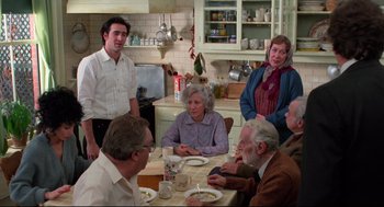 Movie still from “Moonstruck” (1987), directed by Norman Jewison – A group of people sitting around a table in a kitchen; Medium shot, High angle