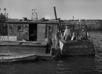 Movie still from “Moontide” (1942), directed by Fritz Lang – A group of people standing on top of a boat in the water; Wide shot, High angle
