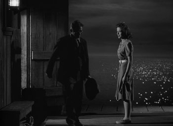 Movie still from “Moontide” (1942), directed by Fritz Lang – A man and a woman standing next to each other on a stage; Medium shot, Low angle