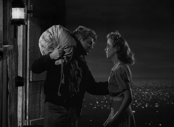 Movie still from “Moontide” (1942), directed by Fritz Lang – A man and a woman standing next to each other; Medium shot, Low angle