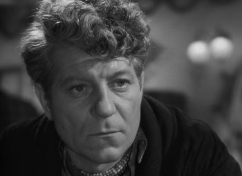 Movie still from “Moontide” (1942), directed by Fritz Lang – Black and white photograph of a man with curly hair; Close Up shot, Over the shoulder angle