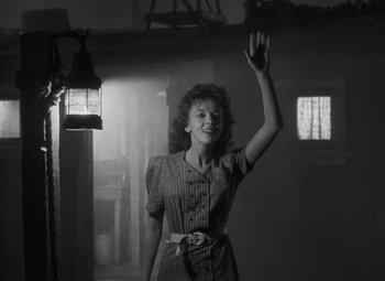 Movie still from “Moontide” (1942), directed by Fritz Lang – A black and white photo of a woman waving; Medium shot, Low angle