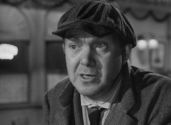 Movie still from “Moontide” (1942), directed by Fritz Lang – An older man wearing a hat and a suit; Close Up shot, Over the shoulder angle