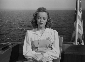 Movie still from “Moontide” (1942), directed by Fritz Lang – A black and white photo of a woman sitting on a boat; Medium shot, High angle
