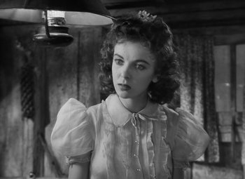 Movie still from “Moontide” (1942), directed by Fritz Lang – A young woman in a white dress looking at the camera; Close Up shot, Low angle