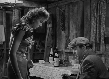 Movie still from “Moontide” (1942), directed by Fritz Lang – A man and a woman sitting at a dinner table; Medium shot, Over the shoulder angle