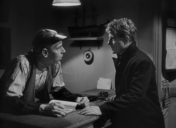 Movie still from “Moontide” (1942), directed by Fritz Lang – Two men sitting at a table talking to each other; Medium shot, Over the shoulder angle