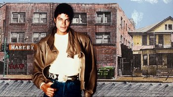 Movie still from “Moonwalker” (1988), directed by Jerry Kramer – A man in a brown leather jacket standing in front of a brick building; Medium shot, Low angle
