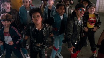 Movie still from “Moonwalker” (1988), directed by Jerry Kramer – A group of young men in leather jackets and hats; Medium shot, High angle