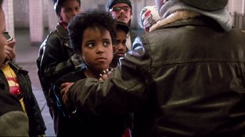 Movie still from “Moonwalker” (1988), directed by Jerry Kramer – A group of young people standing around each other in a room; Close Up shot, Over the shoulder angle