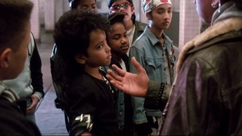 Movie still from “Moonwalker” (1988), directed by Jerry Kramer – A group of young people standing next to each other; Close Up shot, Over the shoulder angle