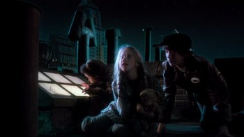 Movie still from “Moonwalker” (1988), directed by Jerry Kramer – A group of people sitting on the ground at night; Medium shot, Low angle