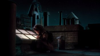 Movie still from “Moonwalker” (1988), directed by Jerry Kramer – A woman sitting on the ground in front of a window at night; Medium shot, Low angle