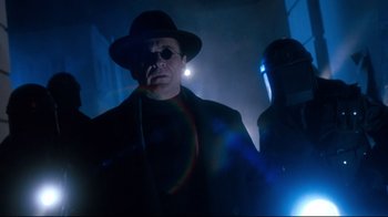 Movie still from “Moonwalker” (1988), directed by Jerry Kramer – A man in a hat and glasses standing next to another man in a hat; Medium shot, Low angle