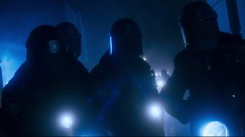 Movie still from “Moonwalker” (1988), directed by Jerry Kramer – A group of police officers standing next to each other in the dark; Medium shot, Low angle