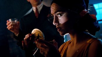 Movie still from “Moonwalker” (1988), directed by Jerry Kramer – A woman in a yellow dress is holding a mirror; Close Up shot, Over the shoulder angle